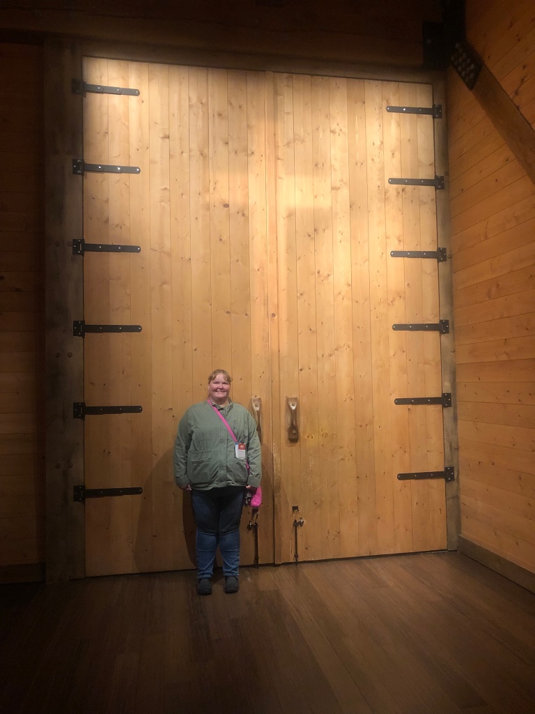 Sarah Deringer, standing in front of the ark doors that has the cross on it. 